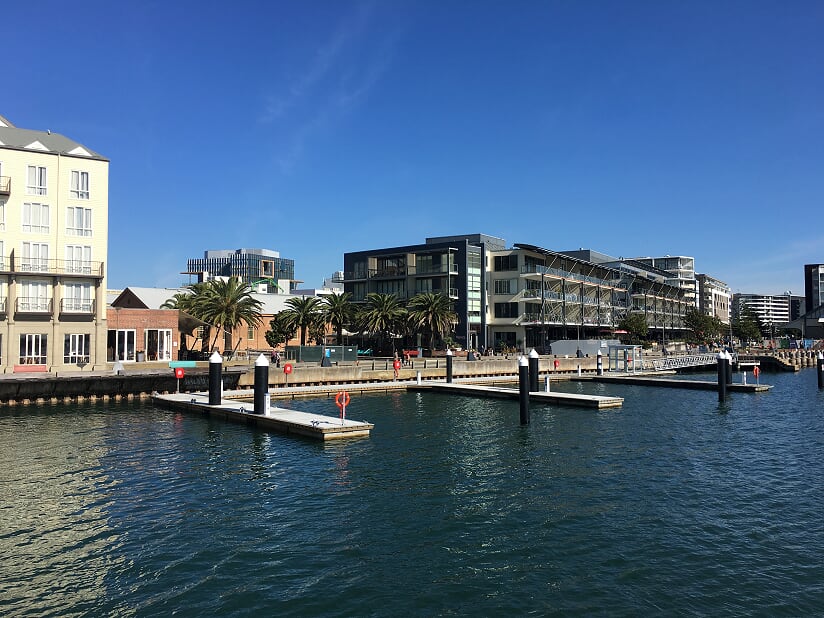 Berths along the promenade with palm trees and apartments